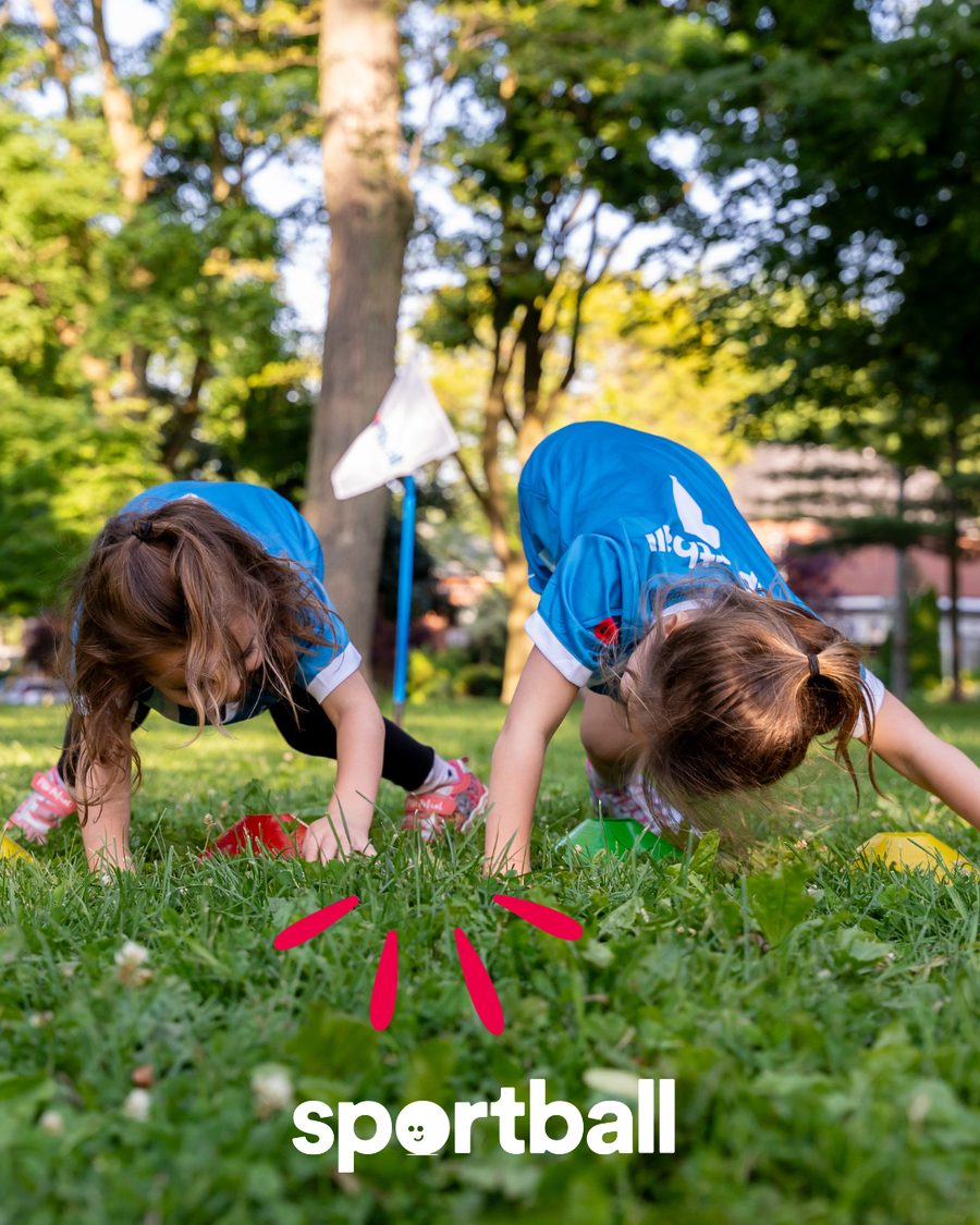 Kids in blue Sportball jerseys playing on the grass at an Austin park