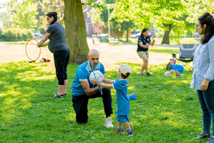 Coach and toddler with a parent at a Sportball Parent and Child class