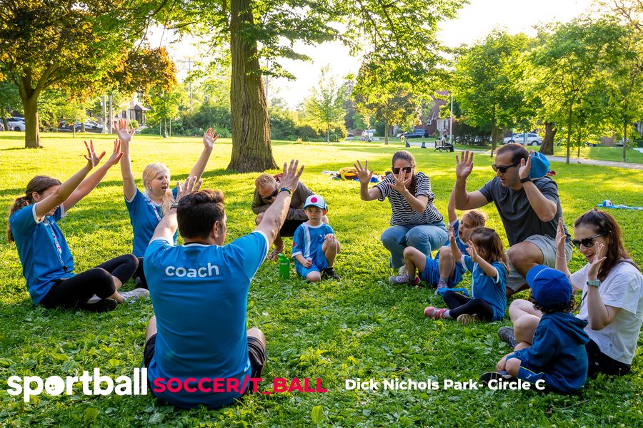 Sportball coach high-fiving kids after a Saturday Soccer and T-Ball class at an Austin park